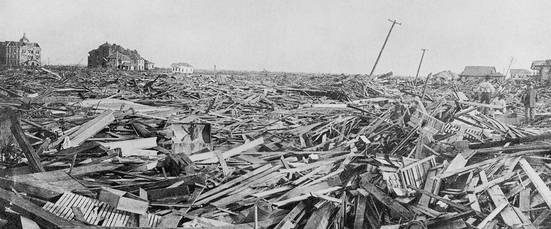 A black and white photo of debris and wreckage from what used to be houses