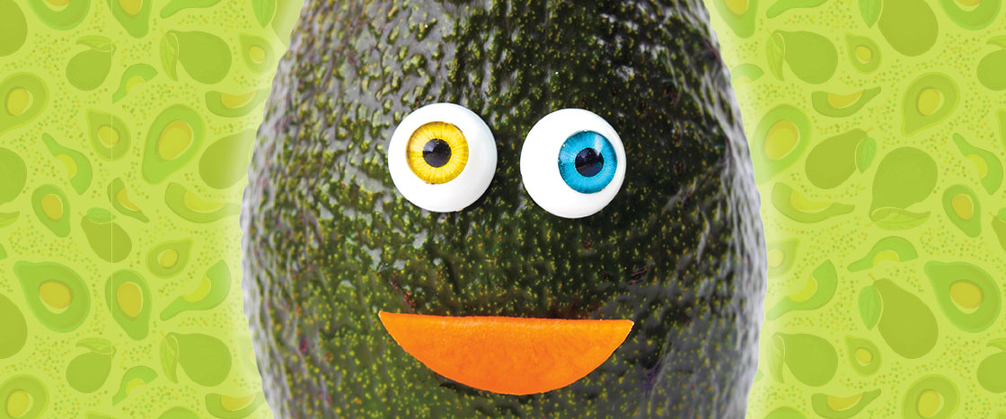 An avocado with a googly eyes and a smile