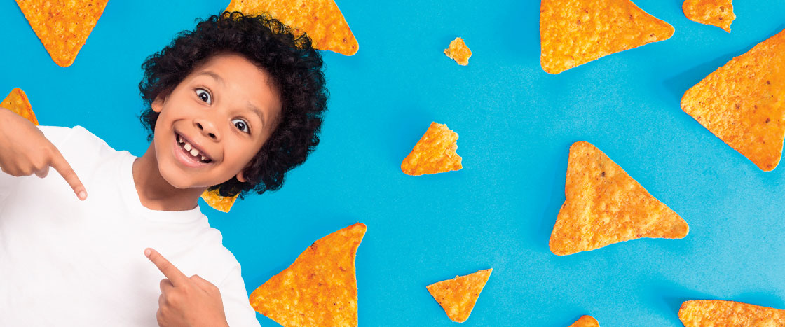 A boy smiling with chips decorating the background