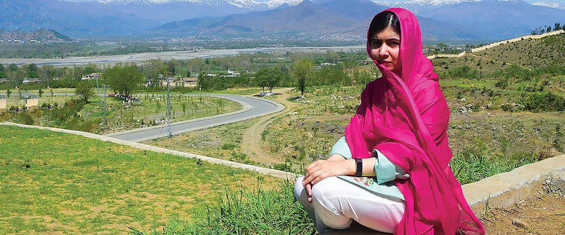 Photo of Malala posing on a hilltop