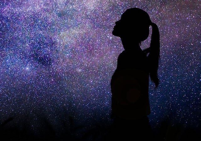 Silhouette of a woman against stars